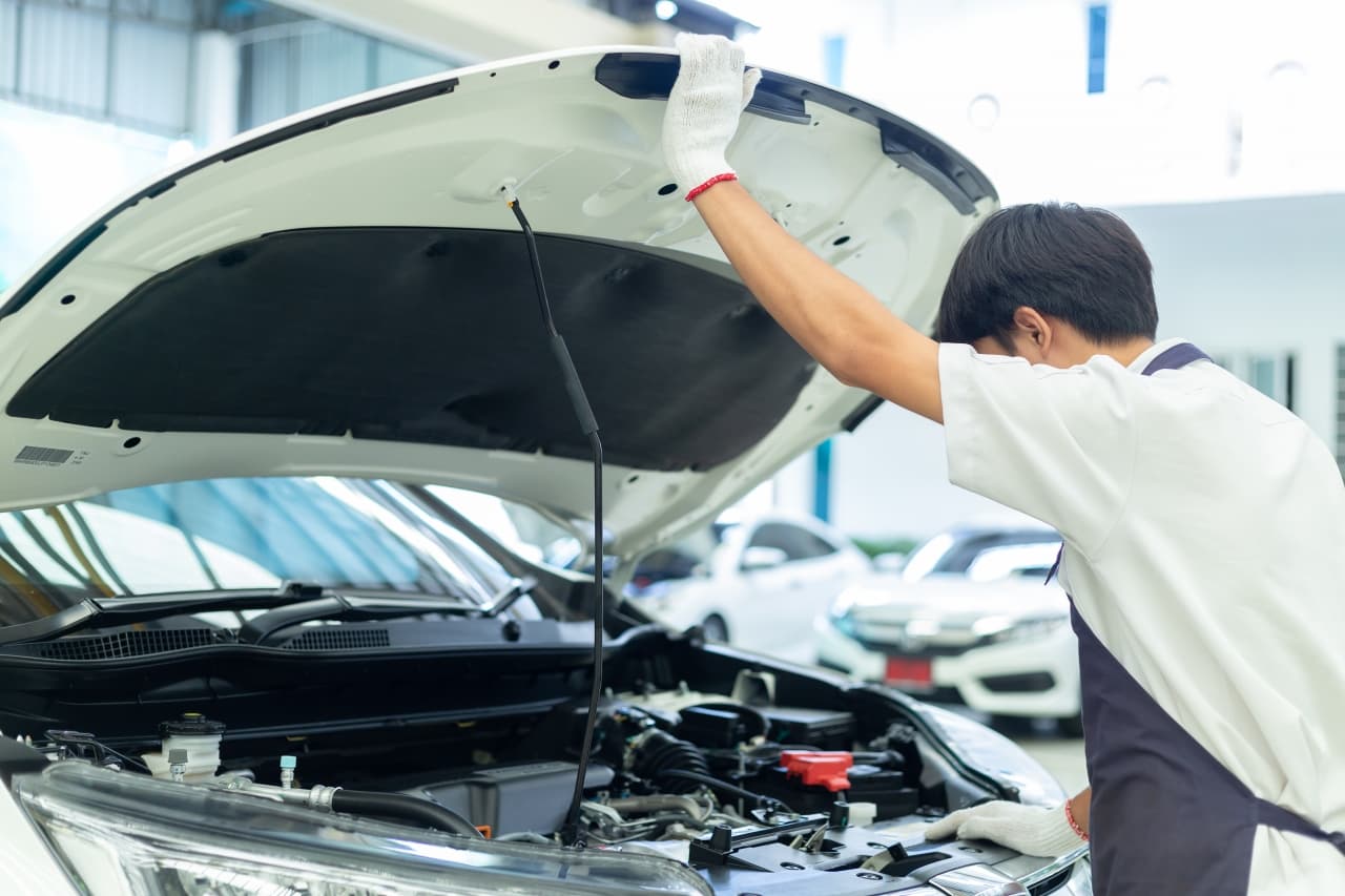 車をメンテナンスする整備士